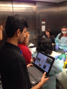 Packed into an elevator for the patient transport, the #UNCsim Hospital Volunteer runs the simulated patient control