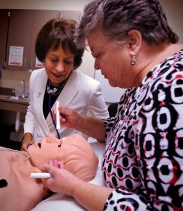 Dr. Carol Durham, right,  EdD, RN, demonstrates pupil dilation to Chancellor Carol Folt using Stan, a human patient simulation mannequin during a tour of the School of Nursing at the University of North Carolina Monday (Aug. 26).